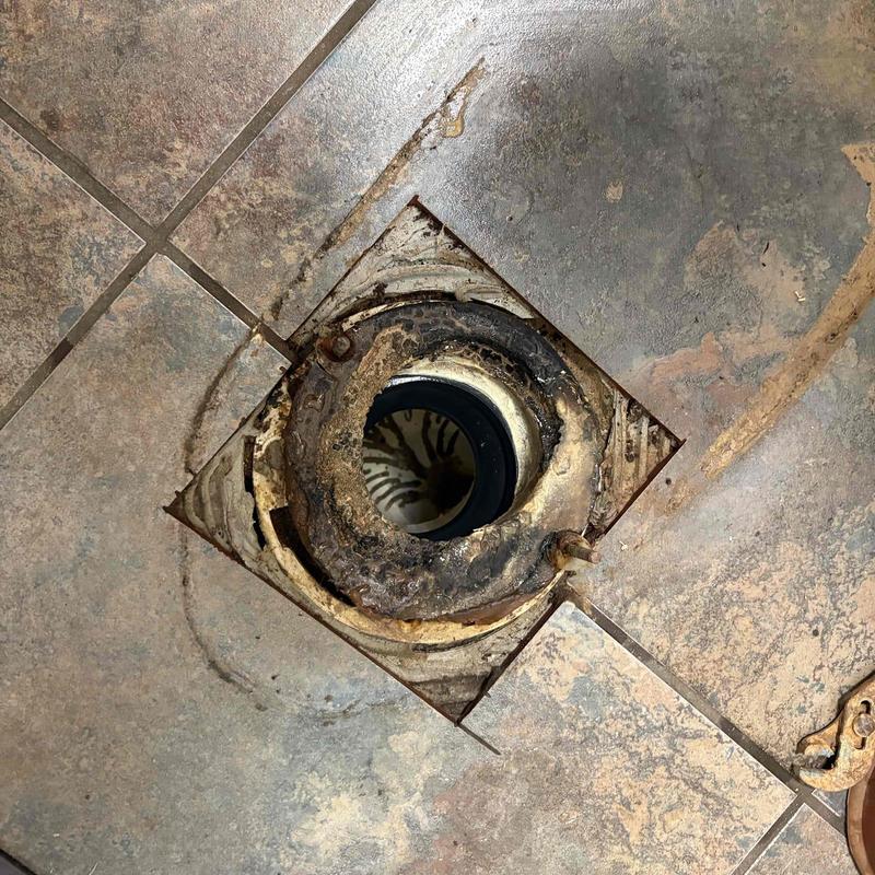 Toilet flange with corroded seal and tiled floor cutout