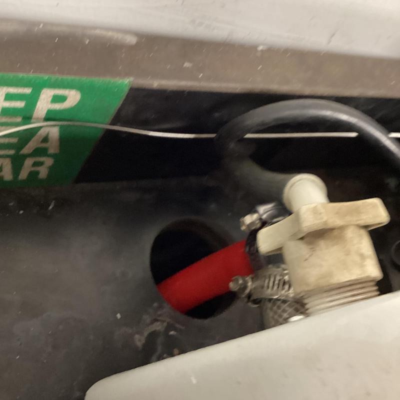 Machine drain line with valve and hose clamp open