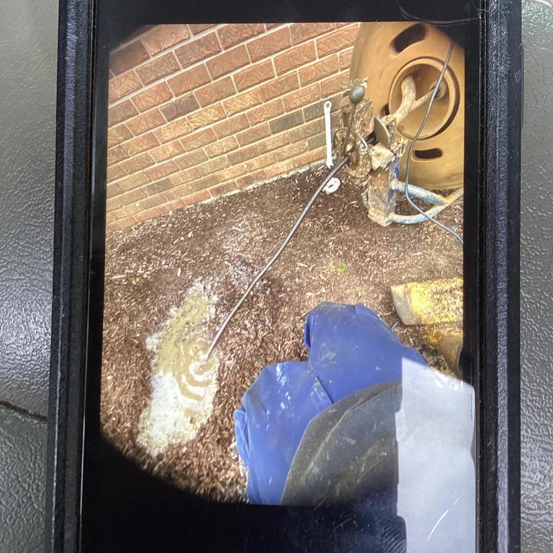 Mainline sewer jetter clearing under mulch and dirt outdoors