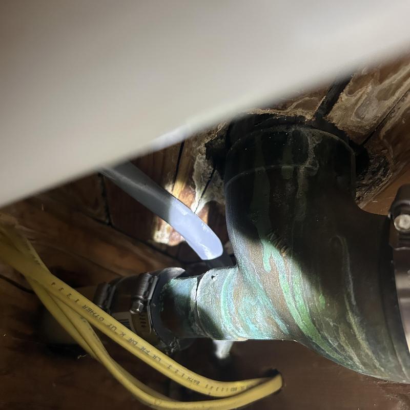 Drain pipe with corrosion and hose clamps under floor Drain pipe with corrosion and hose clamps under floor