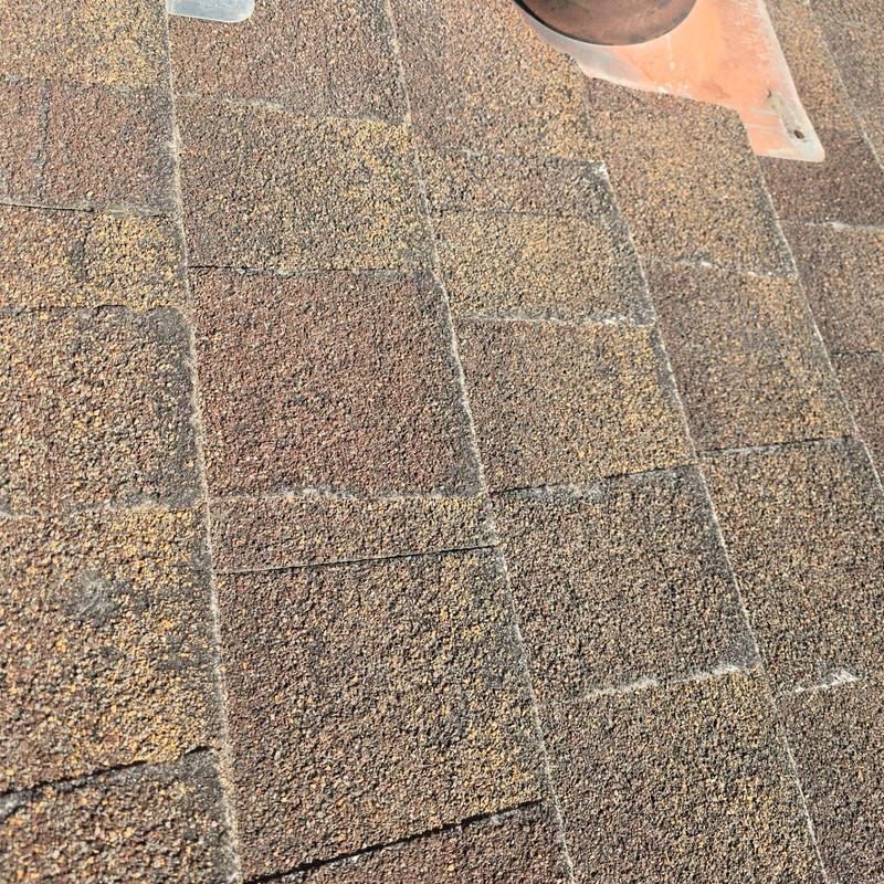 Asphalt roof shingles showing wear and aging near vent pipe Asphalt roof shingles showing wear and aging near vent pipe