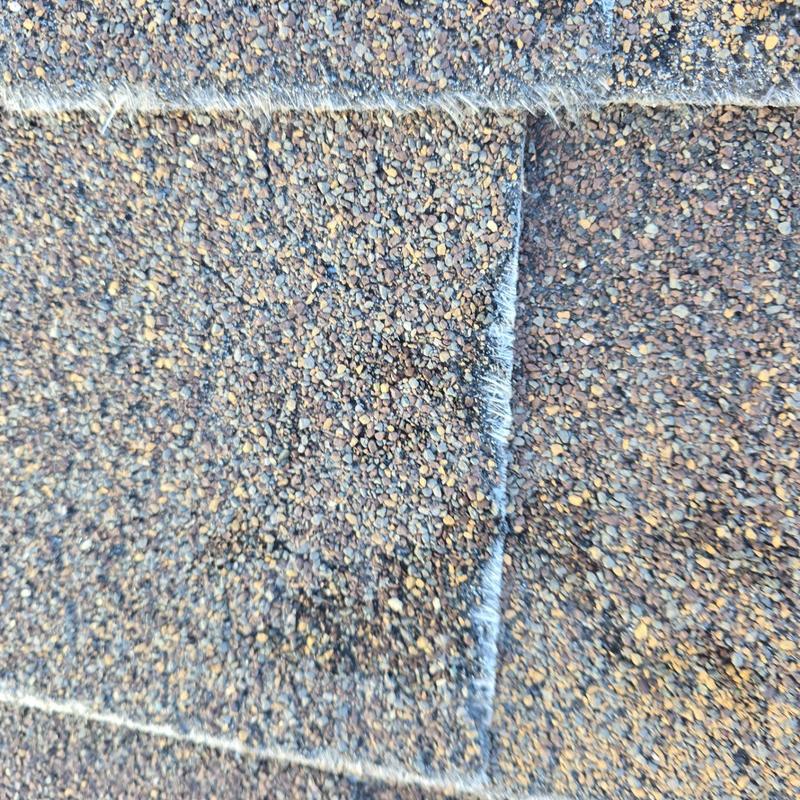 Asphalt roofing shingles close-up showing edge wear Asphalt roofing shingles close-up showing edge wear