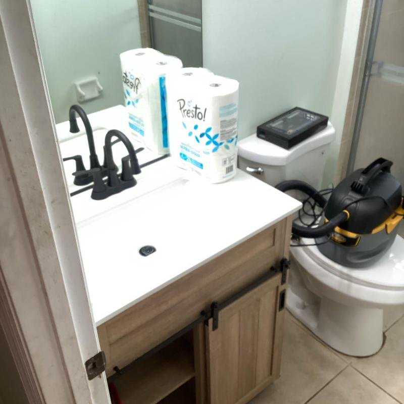 Lavatory vanity with black faucet and plumbing tools