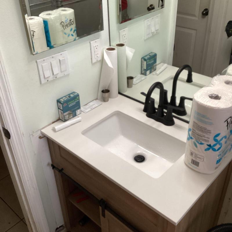 Lavatory vanity with black faucet and white countertop