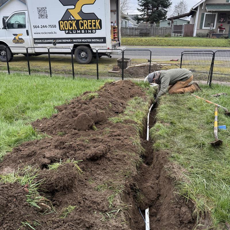 1” water main installation trench with plumber working