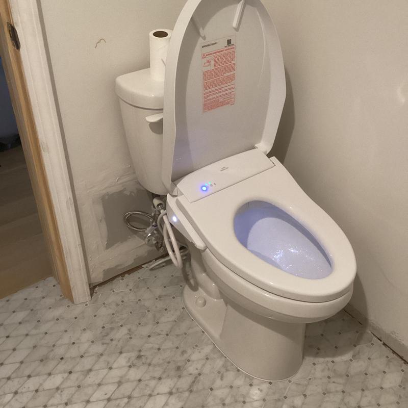 Bidet toilet with spacer flange installed in bathroom