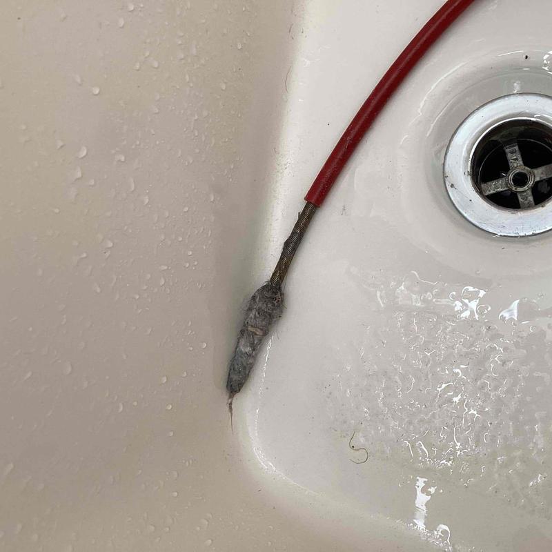 Tub drain line clog clearing with drain snake cable