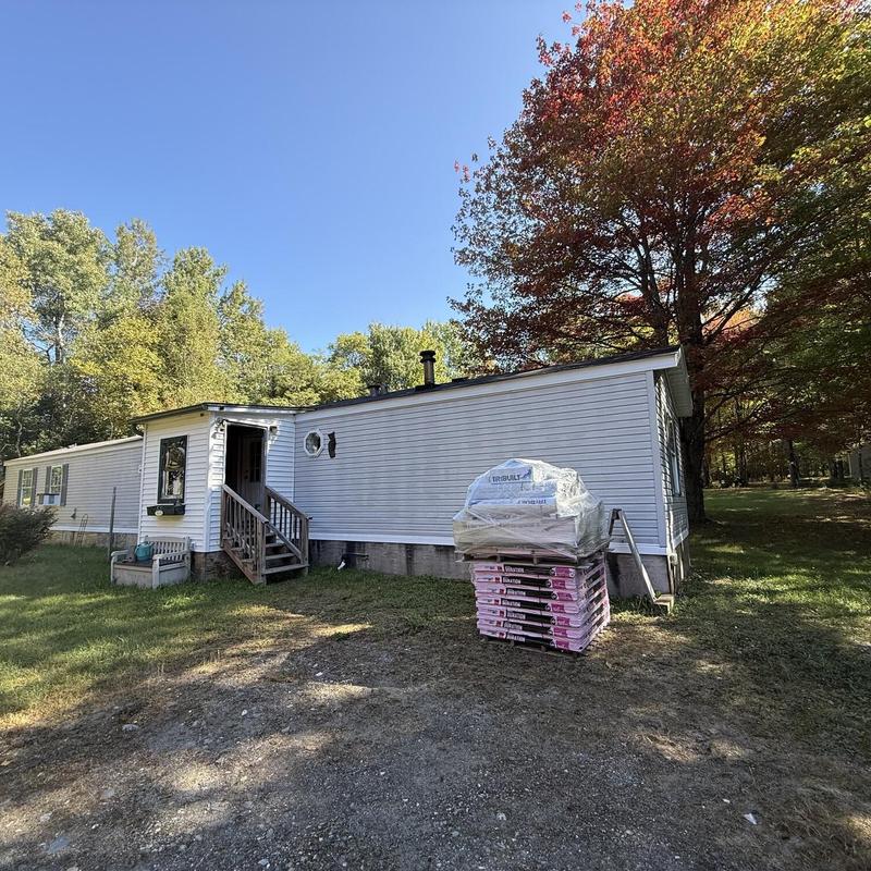 Asphalt shingle roofing materials stacked by mobile home