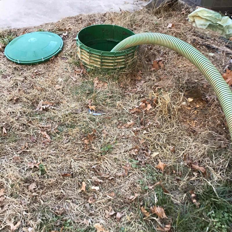 Septic tank access with pumping hose in yard