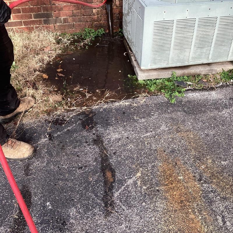 Main sewer line jetting with water puddle near air unit