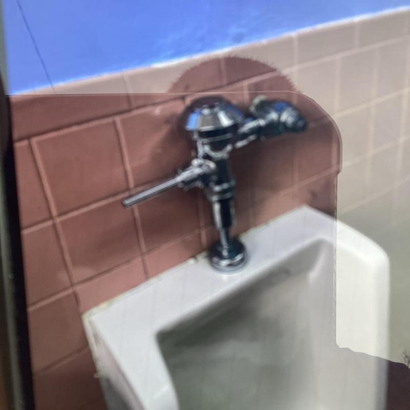Urinal flush valve installation with tiled wall background