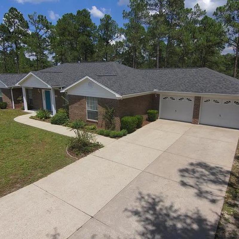 Asphalt shingle roof on brick house with driveway