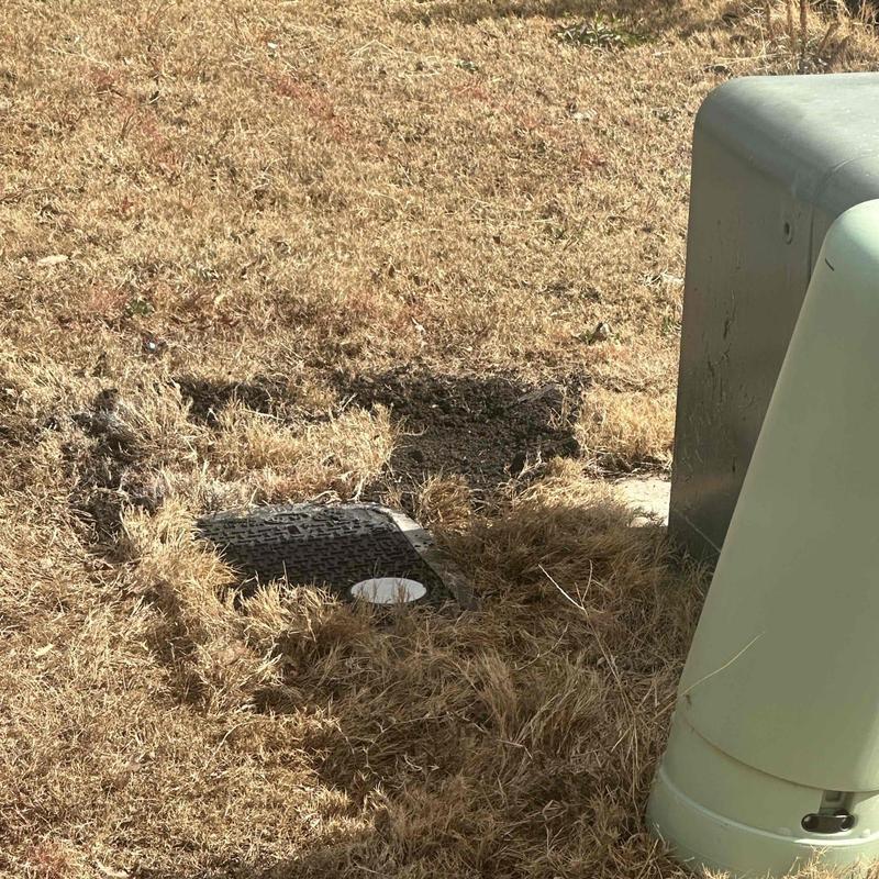 Underground plumbing access with vacuum truck nearby Underground plumbing access with vacuum truck nearby