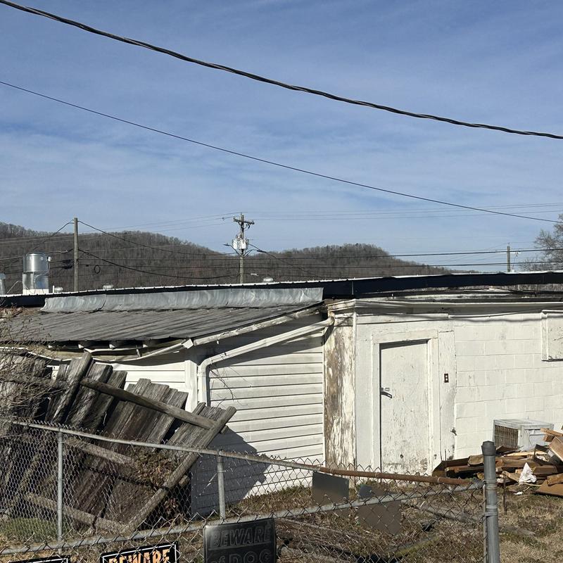 Flat roof with damaged wooden fence outside building