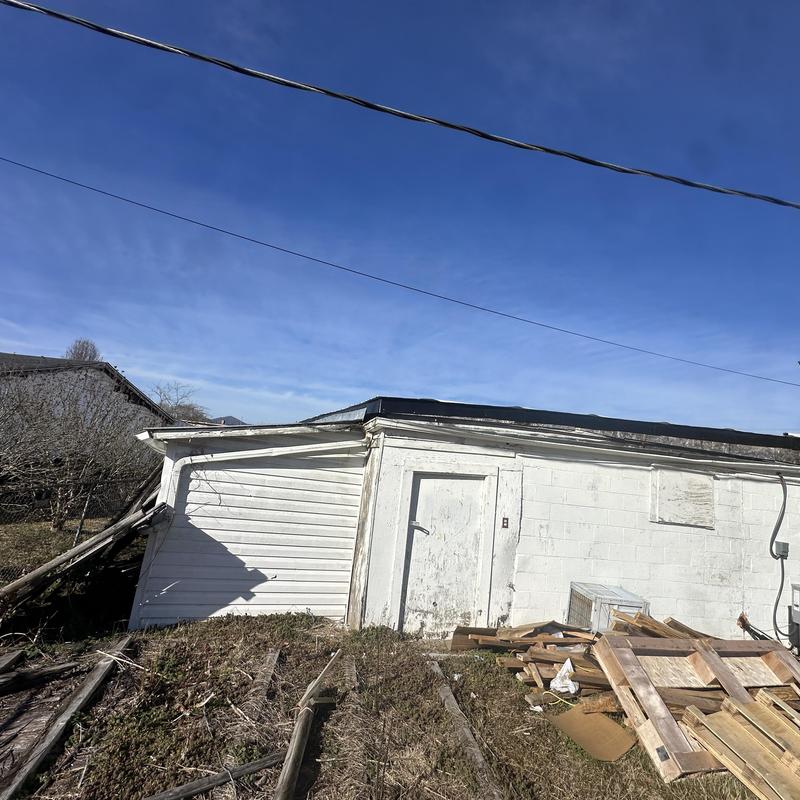 Flat roof and damaged exterior wall on small building