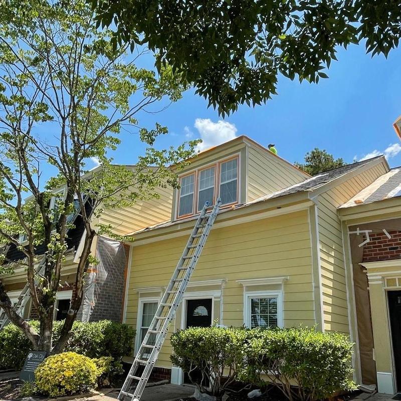 Siding installation on yellow commercial building exterior