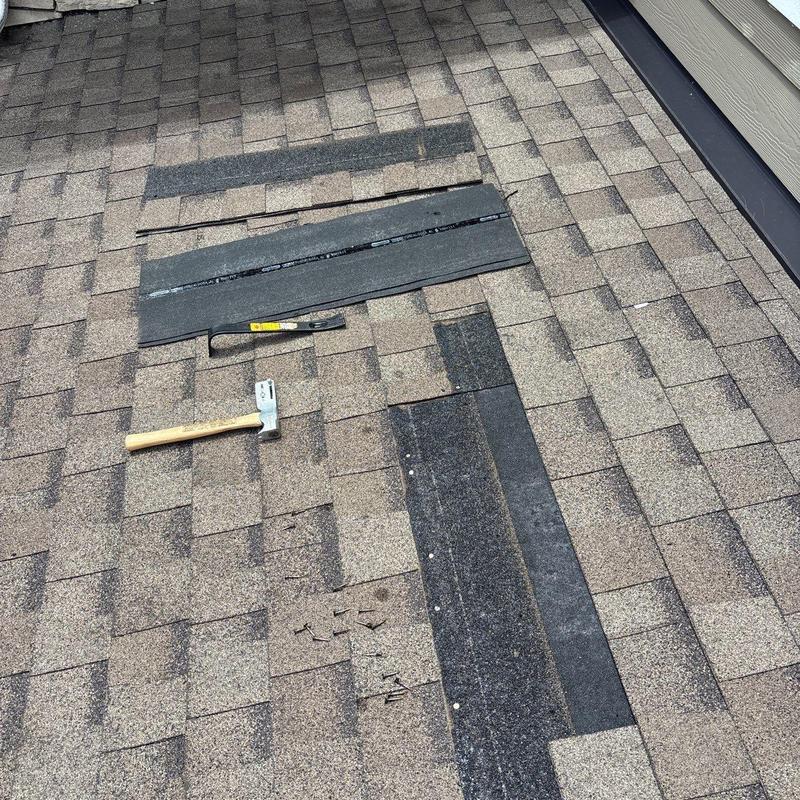 Asphalt shingles roof with hammer and nails on top