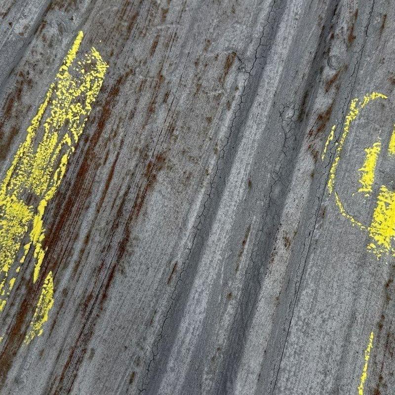 Metal roof panels with hail damage and chalk markings