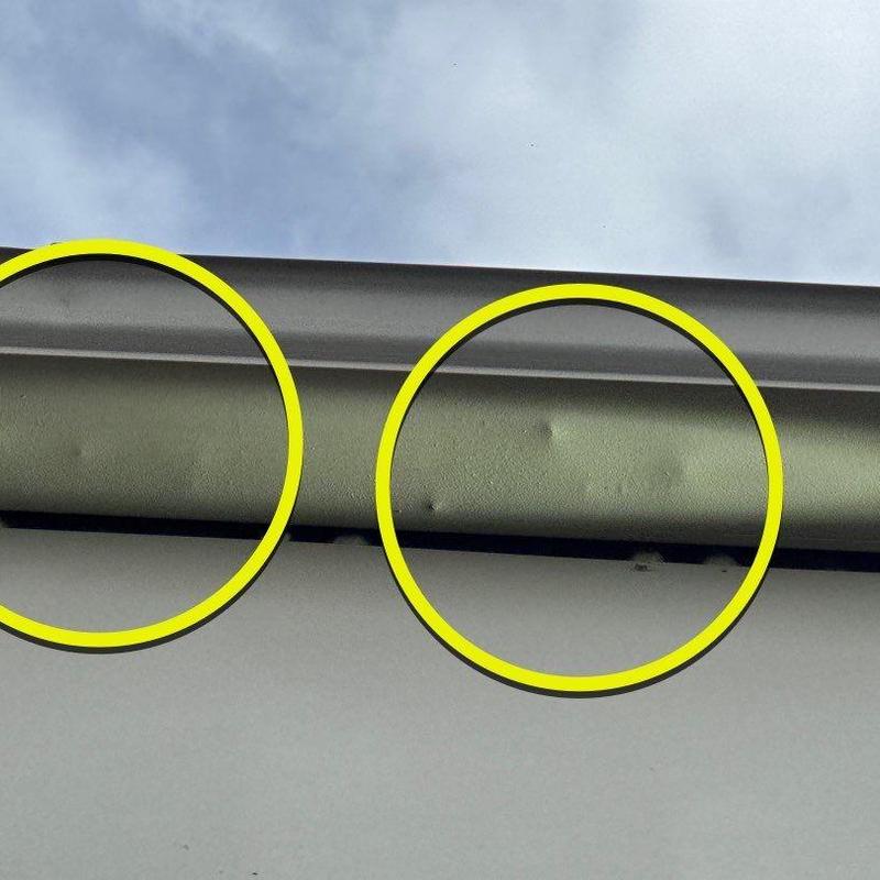 Metal roof flashing with hail impact dents