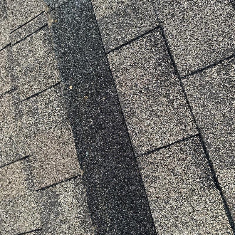 Asphalt roof shingles with hail damage close-up