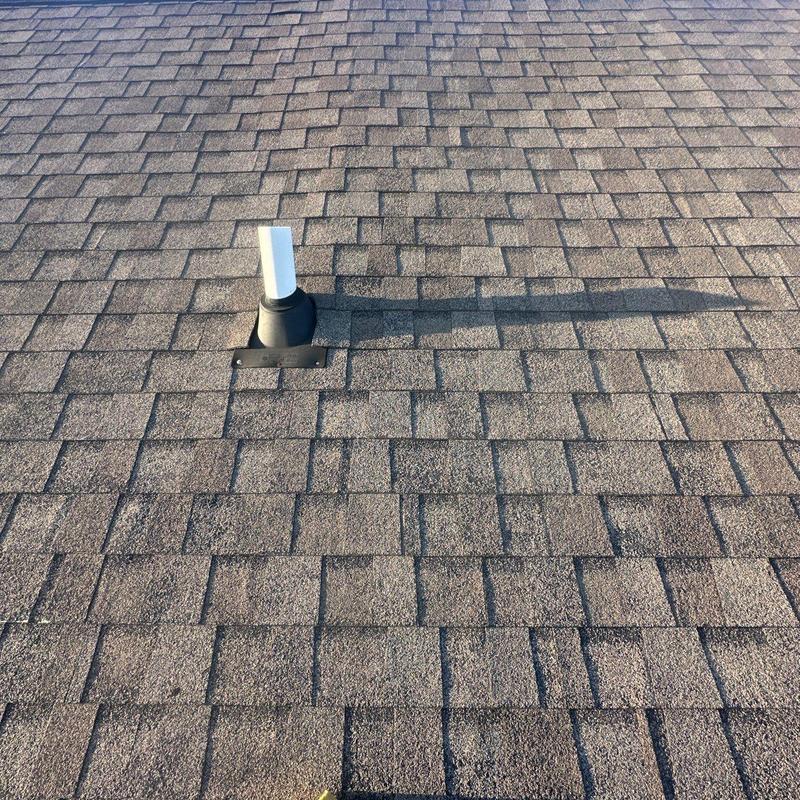 Roof vent flashing on asphalt shingle roof with hail damage