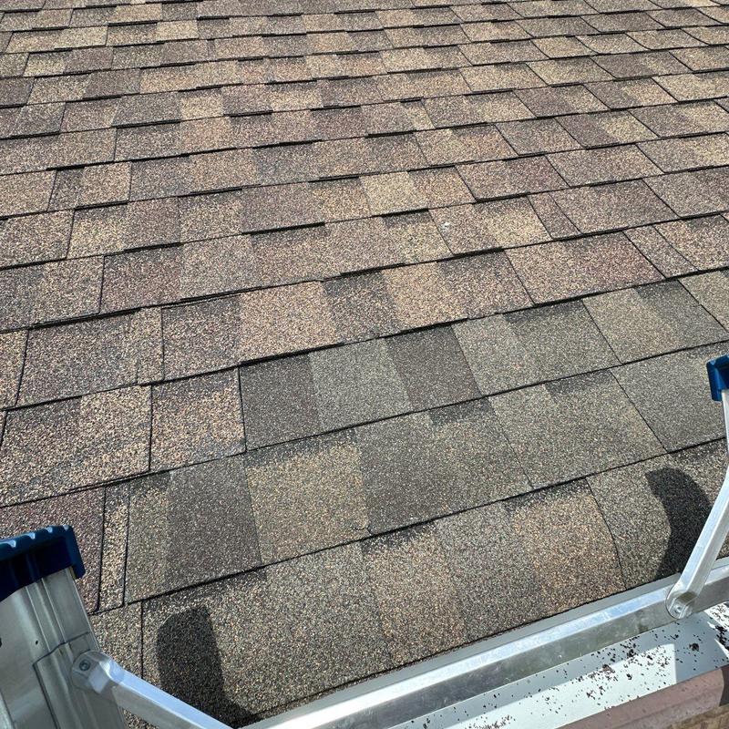 Asphalt shingles with hail damage on roof section