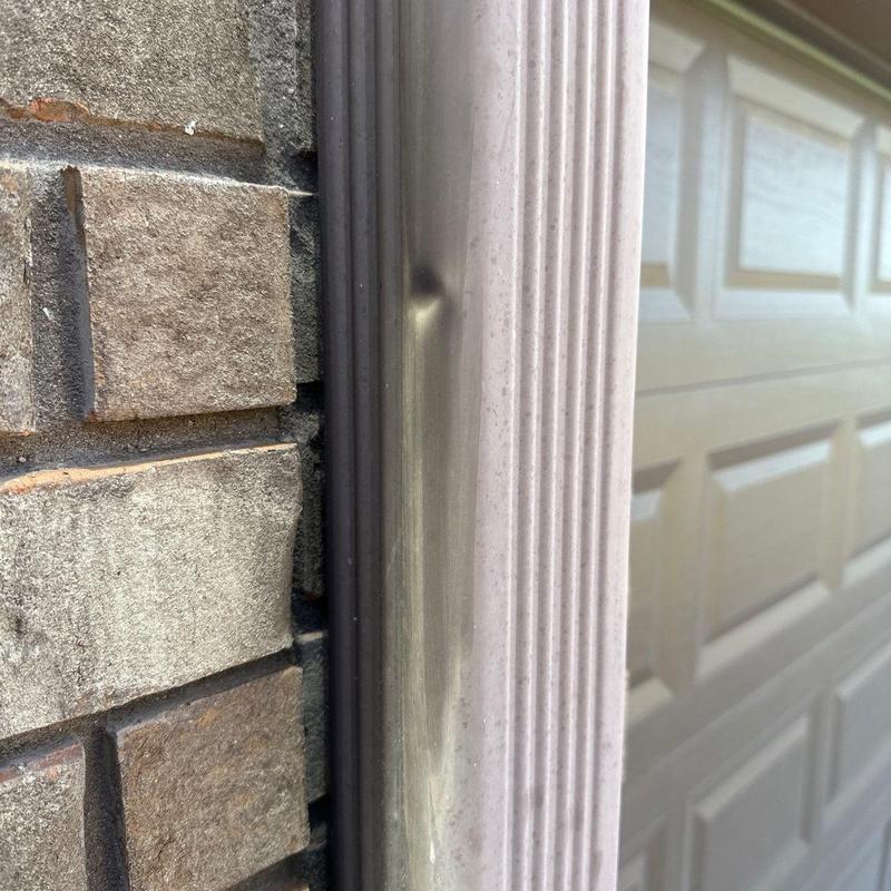 Metal door frame dent damage near brick wall