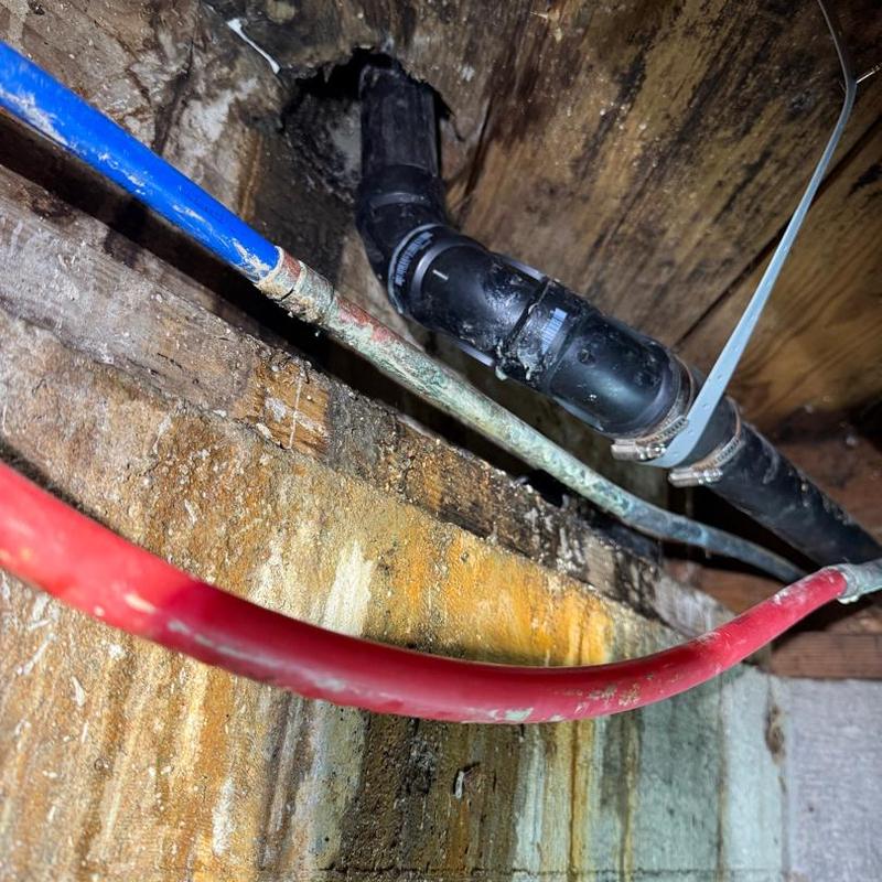 ABS waste piping with metal hangers below floor joists