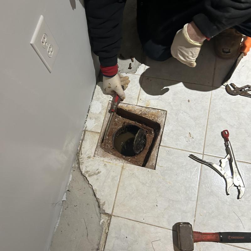 Main line cleanout with rusted cover and tools