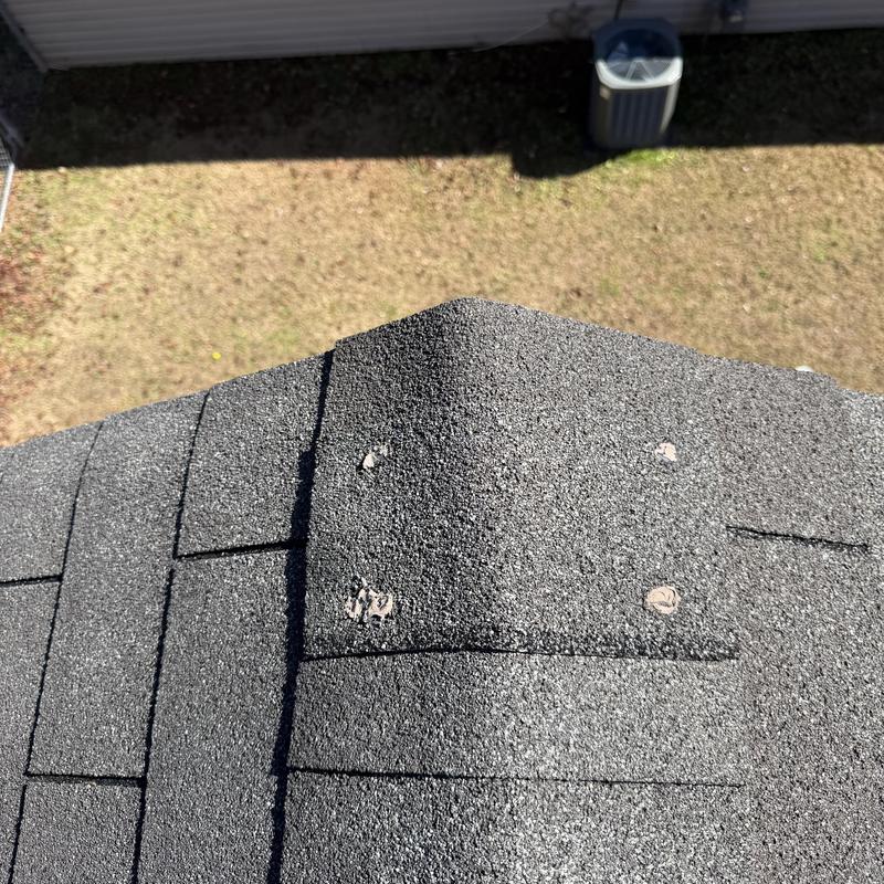 3-tab slate roof ridge caps with exposed nails and sealant wear