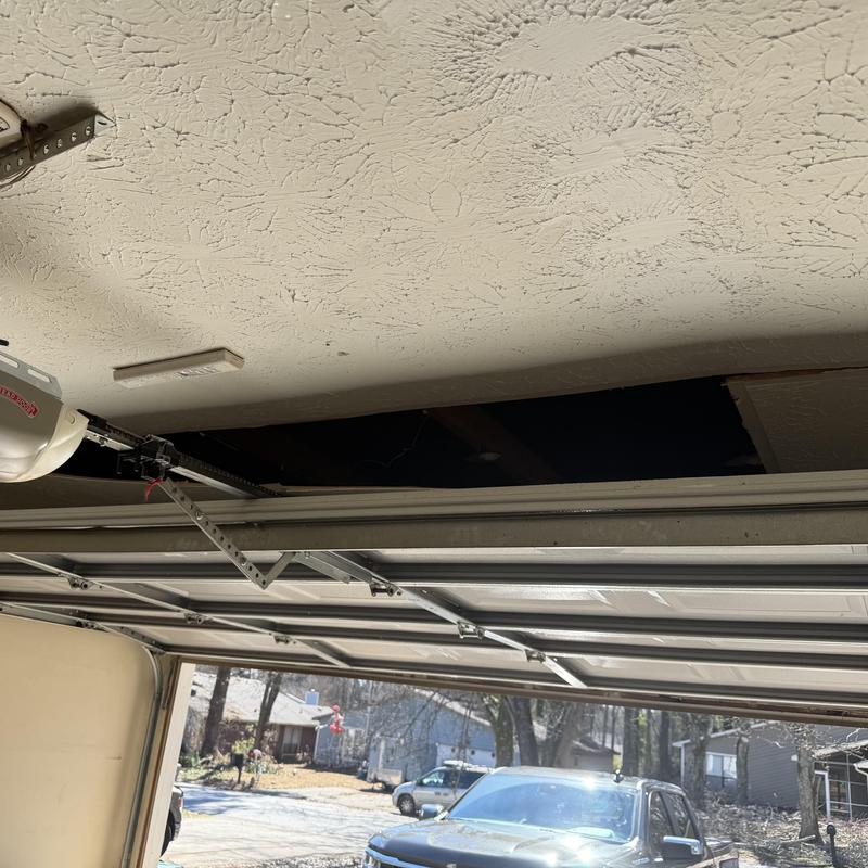 Drywall ceiling with damage above garage door opener
