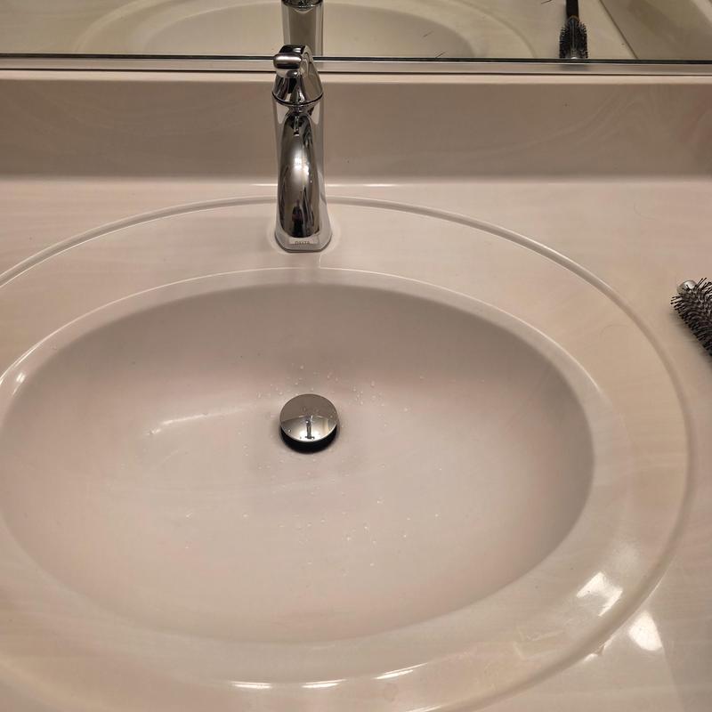 Chrome bathroom faucet with white oval sink