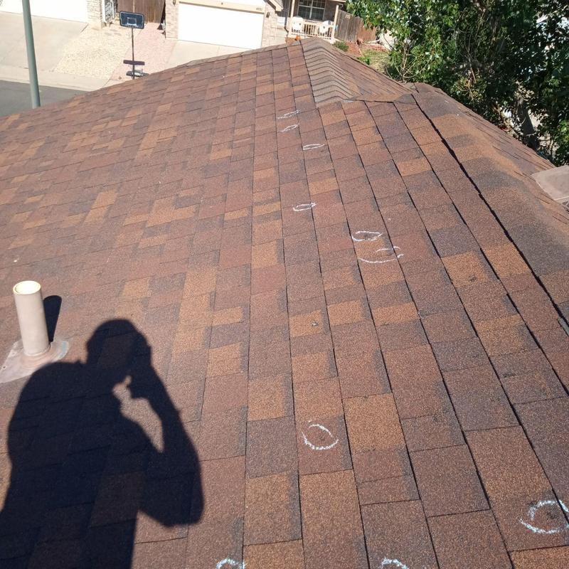 Asphalt shingle roof with hail damage marked for inspection Asphalt shingle roof with hail damage marked for inspection
