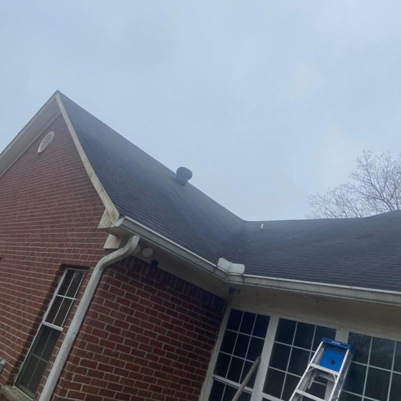 Asphalt shingle roof with visible aging and gutters