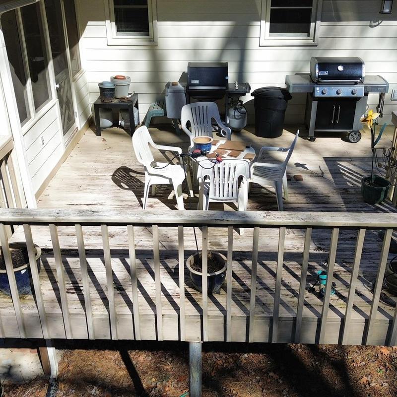 Wooden deck boards with patio chairs and grills
