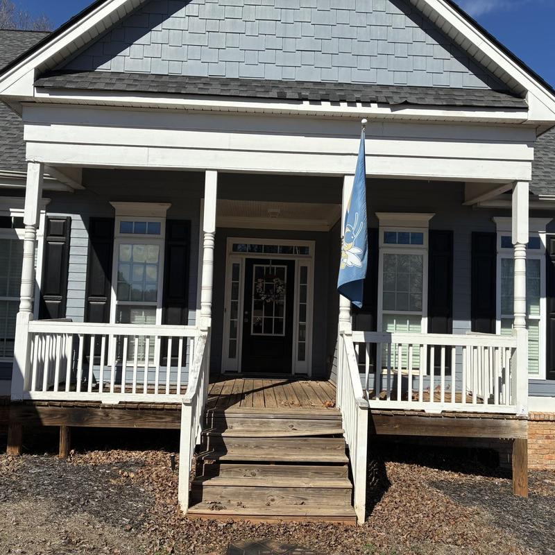 Wooden front porch and stairs with railing