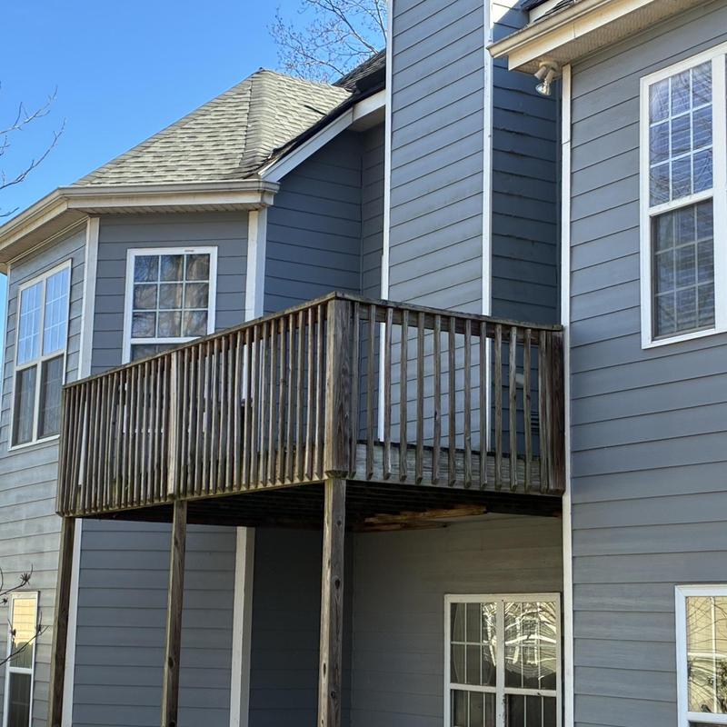 Wooden deck exterior with railings and support posts