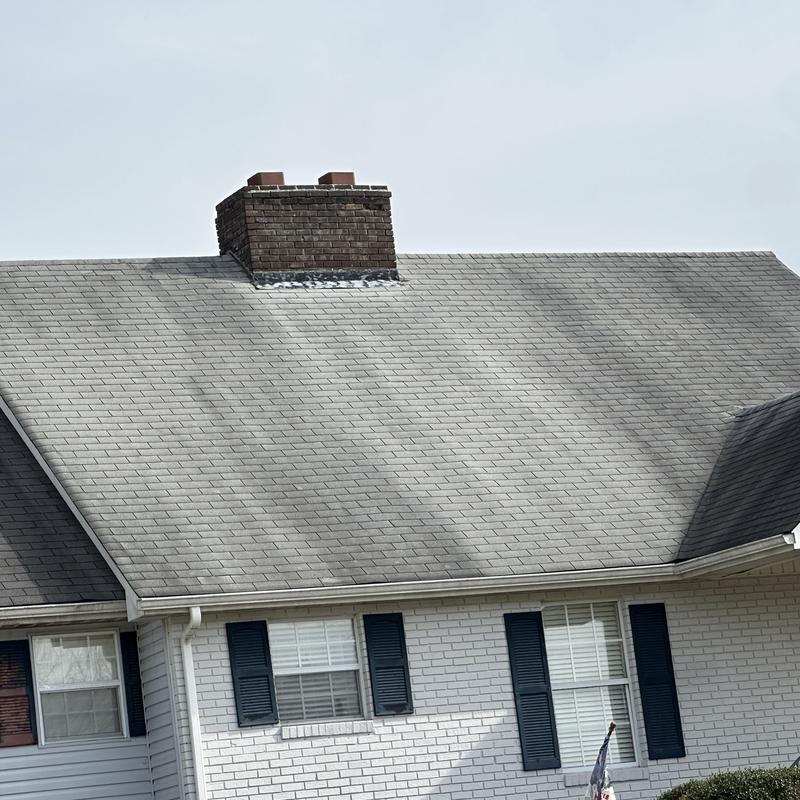 Shingle roof with brick chimney on residential home
