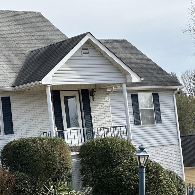 Shingle roof with porch and white brick house