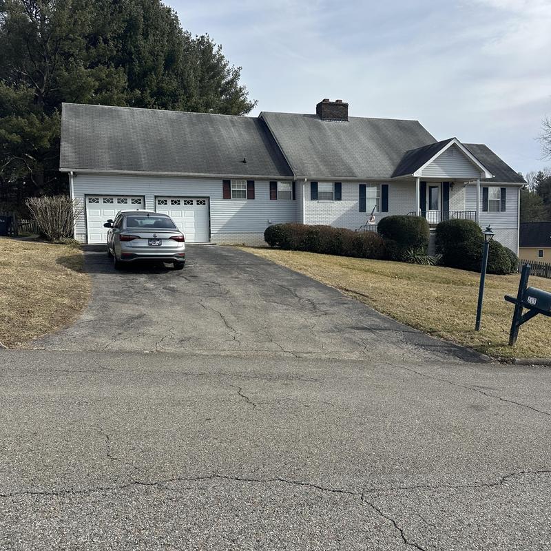 Shingle roof on residential house with driveway and car