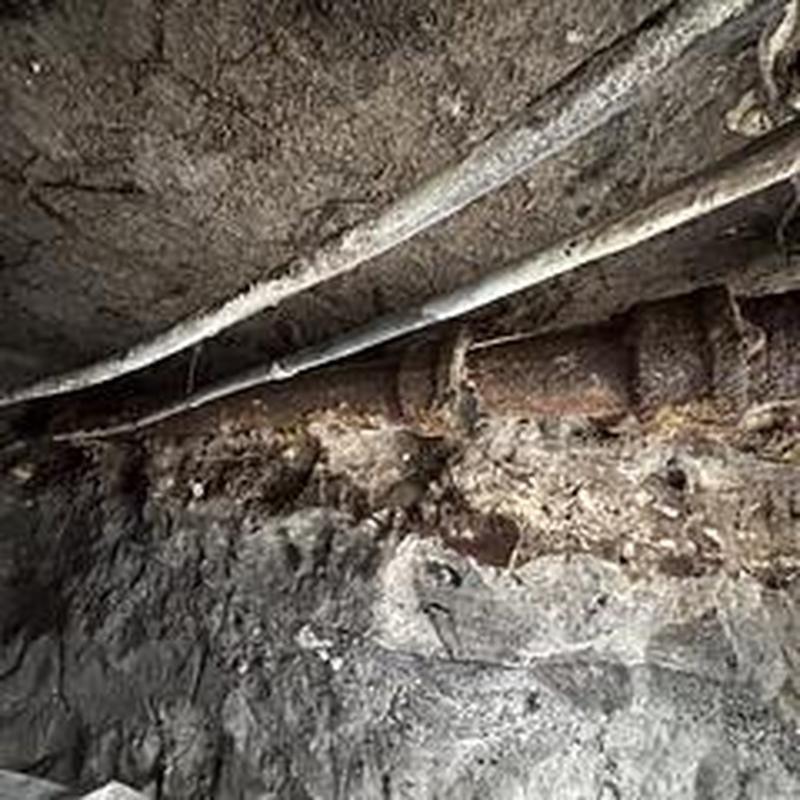 Cast iron drain pipe exposed for replacement under slab