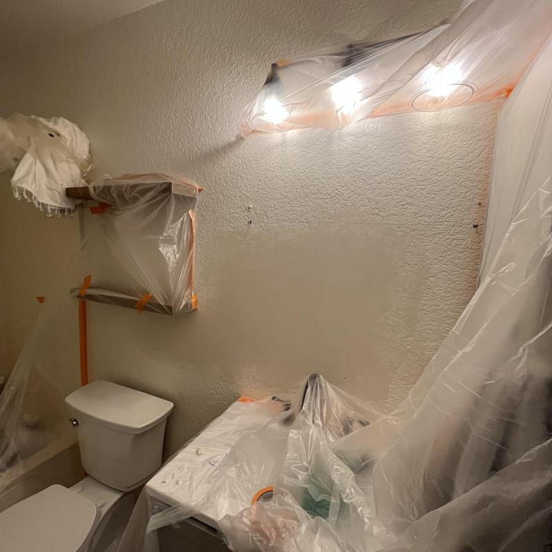 Bathroom light fixture and vanity covered in plastic
