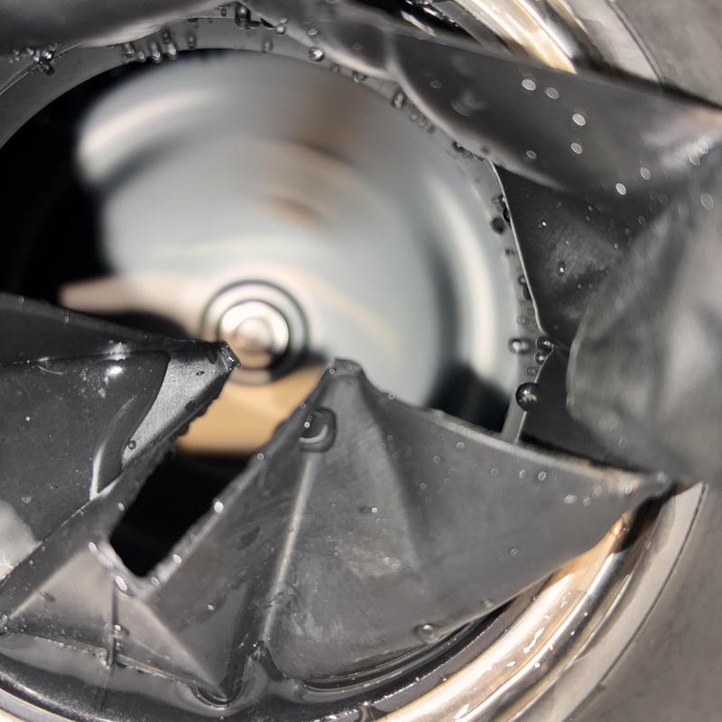 Garbage disposal unit underside close-up with water droplets