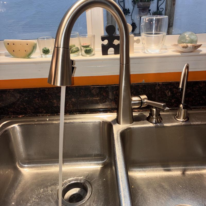 Kitchen faucet with flowing water installed in sink