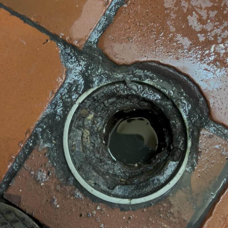 Restaurant drain opening with buildup and water overflow