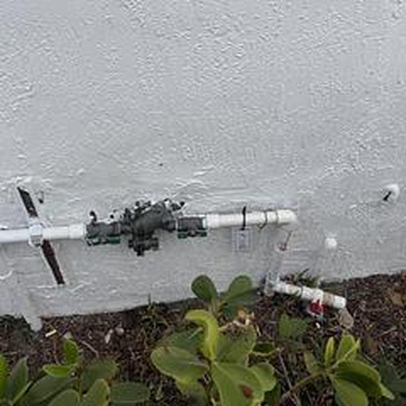 Backflow prevention device with piping against wall