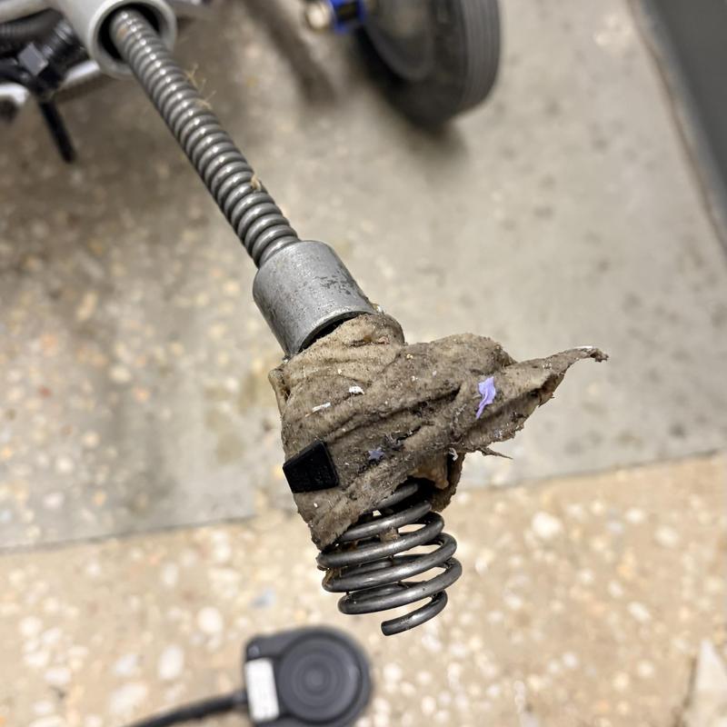 Sewer auger head clogged with debris during cleaning