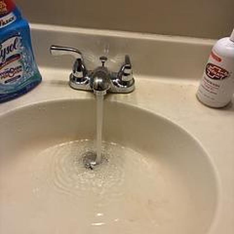 Lavatory faucet with running water in sink basin