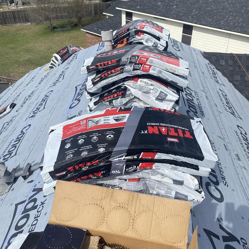 Architectural shingle bundles stacked on underlayment roof deck