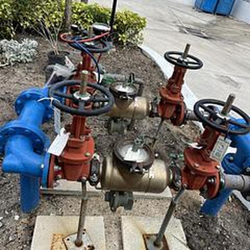 Backflow prevention devices with valves and piping